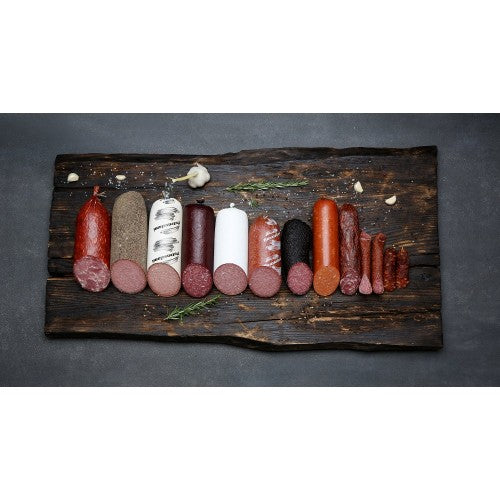 Verschiedene Salamisorten auf einem Holzbrett vor dunklem Hintergrund